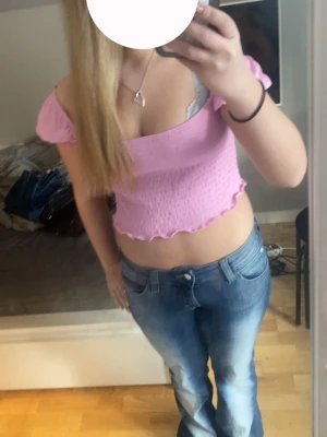 Ljusrosa croppad topp med puffärm - Supersöt ljusrosa croppad topp från med puffiga korta ärmar och smockad struktur. Toppen har vågig kant nertill för en extra gullig vibe💞Den är ny med prislapp, storlek L men skulle mer säga typ S/M