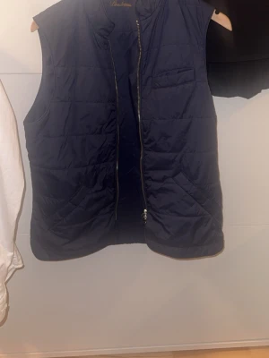 Mörkblå quiltad dunväst från Lindströms - Snygg mörkblå dunväst från stenströms med quiltad design och dragkedja framtill. Västen är ärmlös och väldigt stilig, inga defekter och helt fel fri storlek S och så har fickorna magneter vid stängning hör av er för frågor eller funderingar 