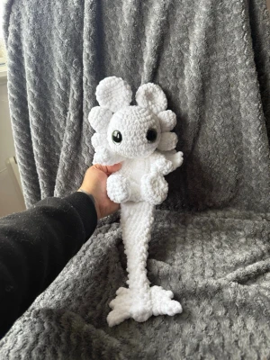 Virkad drake - Handgjord virkad drake  med stora svarta ögon och detaljerade fenor. Perfekt som dekoration eller gosedjur för dig som gillar unika och söta figurer. Materialet är fluffigt och ger en mysig känsla.