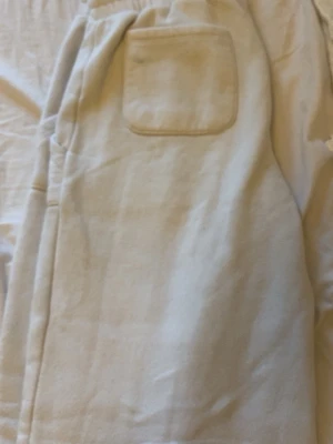 Vita low waist, bootcut mjukisbyxor. - Snygga vita  mjukisbyxor med resår och dragsko i midjan. Byxorna har två stora fickor fram och en bakficka. Tillverkade i mjukt och bekvämt material, perfekta för en avslappnad stil.