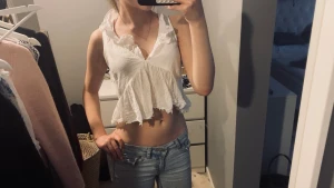 Vit volang topp med v-ringning - Säljer en söt vit topp med volangdetaljer och v-ringning. Toppen är ärmlös och har en croppad passform som ger en luftig och somrig känsla. Perfekt att matcha med jeans eller kjol för en trendig look.