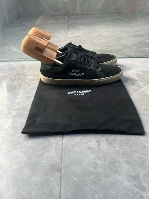 Saint Laurent skor stl41 - Ett par riktigt snygga svarta saint Laurent skor, med slitningar på sidan av skon, mycket bra skick på dem och en påse ingår i priset ny pris 5500 säljer dem för 1100 och kommer inte gå ner i pris!!, skicka ett meddelande vid intresse av att köpa dem.