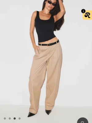 Svart ärmlös linnetopp - Snygg svart linnetopp med breda axelband och djup urringning i ryggen. Toppen har en tight passform och är perfekt för att skapa en clean och stilren look. Tillverkad i mjukt material som sitter skönt mot kroppen. Endast testad