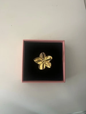Guldfärgad blomring i metall - Säljer en söt Stockholmstil ring med en guldig blomma på. Ringen är justerbar! Jag säljer flera snygga, liknande ringar, blir billigare vid köp av flera!❤️