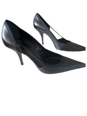 Svarta klassiska pumps i skinn - Snygga svarta pumps med spetsig tå och smal klack. Tillverkade i slätt skinn som ger en elegant look. Perfekta för dig som vill ha en tidlös och stilren sko till garderoben.
