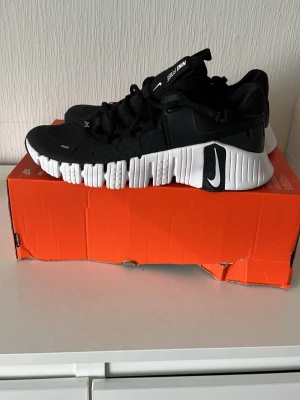 Nike Free svartvita sneakers - Svarta Nike Free sneakers med vit, chunky sula och svart Swoosh-logga på sidan. Skorna har mesh- och syntetmaterial i ovandelen, lågt skaft och snörning. Perfekta för dig som gillar sportig och modern stil.