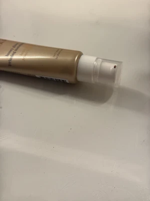 Foundation med pump i beige tub - Foundation i en beige plasttub med vit pump. Tuben har svart text och genomskinligt lock. Produkten är vegansk och dermatologiskt testad, samt passar känslig hud. Innehåller 50 ml och har en naturlig beige ton.
