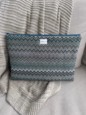 Mönstrad datorväska från Emelo - Snygg datorväska från Emelo med zigzag-mönster i grönt, grått och beige. Väskan har en mjuk textil utsida och dragkedja upptill. Perfekt för att bära din laptop med stil och skydd. Passar laptop med maxmått: 33x24cm