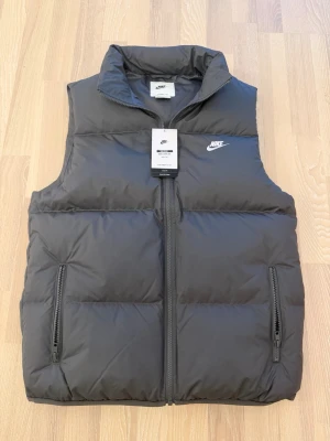 Grå Nike väst - Helt ny grå Nike väst. Västen är oanvänd och jag fick den som present men jag gillar inte västar så säljer den istället. Ettikten är kvar och västen säljs för 300 kr mindre än orginalpriset.