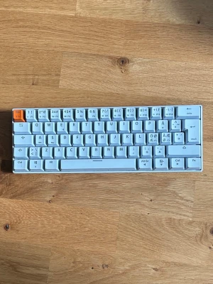 Kompakt vit tangentbord från NOS - Säljer ett kompakt mekaniskt tangentbord från NOS i vit plast med nordisk layout och en orange Escape-tangent. Tangentbordet har låg profil och minimalistisk design, perfekt för dig som vill spara plats på skrivbordet. Passar både till gaming och studier.