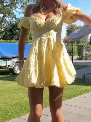 Gul kort klänning med puffärm - Söt gul kort klänning med puffärmar och v-ringning. Klänningen har ett blommigt mönster i tyget och en figurnära överdel som går ut i en volangig kjol. Perfekt för sommarens alla tillfällen! Pris kan diskuteras! Lånade bilder🩷