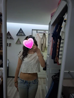 Vit spets-croptop med kort ärm - Säljer en söt vit croptop i spets framtil  med korta ärmar och rund hals. Toppen är perfekt till jeans eller kjol. Passar dig som gillar en feminin och trendig stil. Finns ingen lapp i men skulle gissa på typ storlek S.