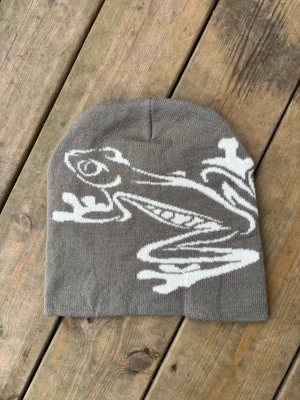 Grå / vit Beanie mössa med groda y2k Winter  -  Grå mössa med vitt grodmönster. One size storlek. Ny. Unisex.  