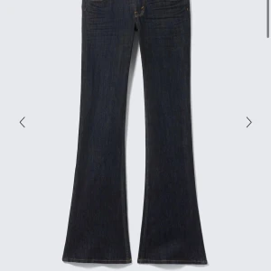 Mörkblå bootcut jeans cheap Monday  - Snygga mörkblå bootcut jeans med klassisk femficksdesign och utsvängda ben. Jeansen har en hög midja och är tillverkade i ett mjukt denimtyg som ger en skön passform. Perfekta för dig som gillar retrovibbar och vill ha ett par jeans som sticker ut. 25/32