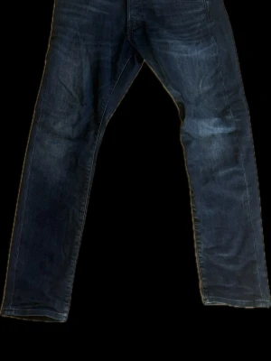 Jack&jones intelligence slim jeans  - Snygga mörkblå jeans med slim passform och klassisk femficksdesign från Jack&jones . Jeansen har subtila slitningar och är tillverkade i denim. Perfekta för en avslappnad och trendig look.