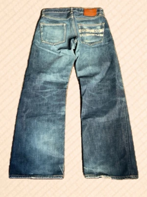 Momotaro jeans  - Extremt clean pair av Momotaro jeans med top-tier fades – exakt den typen av slitning som tar lång tid att få fram naturligt. Riktigt fin kontrast och tydlig karaktär genom hela paret.  Battle stripesen är dessutom ovanliga med ett annorlunda mönster än standard, vilket gör detta till ett betydligt mer unikt par än de flesta på marknaden. Svårt att hitta liknande i den här nivån.  Mått: Midja: 37 cm Längd: 95 cm Innerben: 70 cm Lår: 25 cm Benöppning: 21 cm