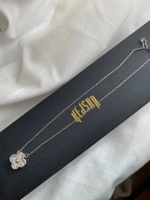 Silverhalsband Kejsar - Elegant silverhalsband från Kejsar med en vacker blomformad hängsmycke. Perfekt för att lägga till en touch av elegans till din stil. Kommer i en stilren svart smyckesask. Nyskick! Orginalpris ca. 1200 kr. 