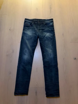 Diesel jeans - Säljer ett par mörkblå jeans med snygga slitningar framtill. Jeansen är perfekt nu till våren. Vid frågor eller prisförslag tveka inte på att höra av er!