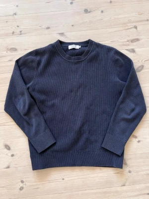 Ljung stickad tröja  - Mörkblå stickad tröja från Ljung by Marcus Larsson. Tröjan har rund halsringning, långa ärmar och är ribbstickaf . Enkel och stilren design som passar perfekt till många olika outfits. Nypris 1500