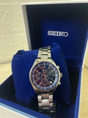 Seiko silverfärgad kronografklocka - Stilren Seiko kronografklocka med silverfärgad länk i metall och mörkblå urtavla. Klockan har tre subdials, datumvisning och tydliga vita markeringar. Perfekt accessoar för dig som gillar klassisk och sportig stil.