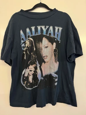Aaliyah t-shirt med tryck - Cool t-shirt med stort Aaliyah-tryck framtill i blått och vitt. Oversized passform och klassisk rund hals. Perfekt för dig som gillar retro och musikikoner. Tillverkad i mjuk bomull för skön känsla hela dagen.