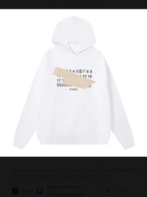  Maison Margiela hoodie - Snygg vit hoodie från Maison Margiela med tryck framtill i form av siffror och beige tejpdetalj. Klassisk huva och känguruficka. Tillverkad i mjukt bomullsmaterial för en clean och modern look.