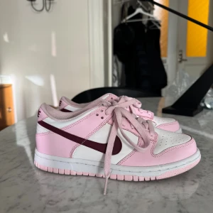 Nike Dunk Low – stl 36,5 (US 4Y) - Superfina Nike Dunk Low i ljusrosa. Mycket fint skick – endast använda fåtal gånger. Lite smuts på sulorna men i övrigt väldigt fräscha.  Storlek 36,5 / US 4Y / 23 cm (se bild på innerlapp).
