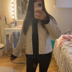 Beige kappa med stora fickor - Snygg beige kappa med stora knappar och två rejäla fickor framtill. Jackan har en rak, lite boxig passform och är perfekt att slänga över en hoodie eller t-shirt. Stilren och enkel att matcha till det mesta. Stl 160 men passar mig som har xxs/xs