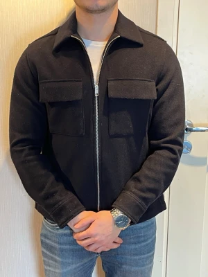 Mörkblå overshirt med fickor - Stilren svart overshirt med dragkedja framtill och två stora bröstfickor.