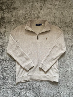 Ralph Lauren quarter zip - Riktigt fin 1/4 zip i beige färg och fint skick. Tröjan är Storlek S men passar något mindre, närmre en xs om man frågar mig. Hör gärna av dig vid frågor🫡