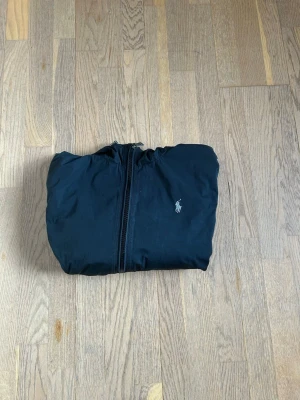 Ralph lauren jacka - Ralph lauren windbreaker i svart, storlek M. Tecken på användning men fortfarande fin. Vid några funderingar är de bara att skriva 