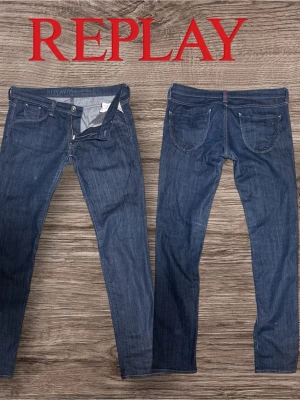 Mörkblå jeans från Replay - Säljer ett par mörkblå jeans från Replay med klassisk femficksmodell och dragkedjegylf. Jeansen har raka ben och är tillverkade i slitstark denim med snygga kontrastsömmar. Perfekta för en avslappnad och stilren look.