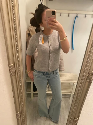 Grå kofta med kort ärm & pärlknappar - Mysig ljusgrå kofta med rund halsringning och korta ärmar. Den är oanvänd och har prislapp kvar. Köpt för 229kr säljer för 140kr💕💕