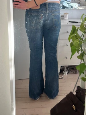 Blå bootcut jeans från Levi's - Säljer ett par klassiska blå bootcut jeans från Levi's. Säljer eftersom att de är lite för små för mig! Skriv om midjemått eller något annat!