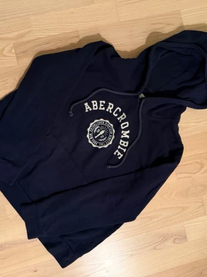 Abericrombie & fitch hoodie - Riktigt fet abercrombie hoodie i storlek M men passar folk i S bättre. Den har inga skavanker alls och den är i väldigt fint skick.