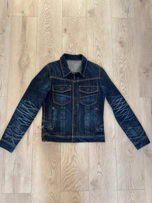 Mörkblå jeansjacka från Deeta - Riktigt snygg och sällsynt jeans jacka i raw denim från Deeta. Tillverkad i Japan i selvedge och har ruskigt snygga detaljer/slitningar. Storlek S. Tveka inte på att höra av dig om du har frågor! Priset är ej hugget i sten.