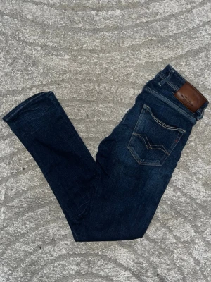 Replay Anbass jeans  - Snygga Repaly Anbass jeans med kontrastmönster. Jeansen har en slim och skön passfrom. Midja 34cm, längd 101cm. JAG SKICKAR EJ FLER BILDER NÄR JAG BÄR JEANSEN! för bättre inblick i passformen rekommenderar jag att googla på modellnamnet. För storleksguide kolla måtten noggrant då jeansen alltid kan vara uppsydda heller krympta och jag ej tar emot returer :) 1,82