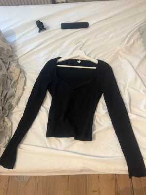 Svart ribbad topp från Nelly - Snygg svart långärmad topp från Nelly med ribbad struktur och en djup v-ringad halsringning. Säljer då den inte kommer till användning💕 fin 💕