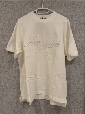 Vit t-shirt från Acne Studios - Tjena Säljer en tvärfeta stilren vit t-shirt från Acne Studios med broderad logga framtill. T-shirten matchar med allt och är jätte stilig.