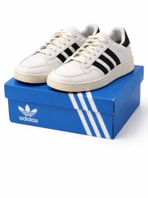 Adidas Team Court sneakers 42⅔ svart/vit – bra skick - Klassiska vita sneakers sopade med svarta Adidas-ränder på sidorna. Lågt skaft och retrovibbar, tillverkade i läder med gummisula. Perfekta för dig som gillar stilrena och tidlösa skor med ikonisk design.