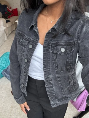 Svart jeansjacka från Vero Moda - Svartgrå jeansjacka från Vero Moda i strl xs. Väldigt fint skick på utsidan men lite nopprig på insidan (se bild). 
