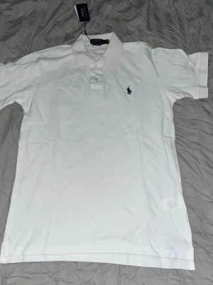 Vit pikétopp från Polo Ralph Lauren - Klassisk vit pikétröja från Polo Ralph Lauren, extremt bra skick. 🛑Skriv vid funderingar.         🛑Enkel affär=kan gå ner i pris