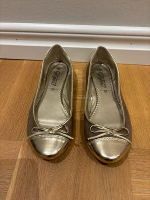 Guldiga ballerinaskor - Fina guldiga ballerinaskor, perfekt inför sommaren! Bra skick !