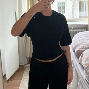 Svart croppad topp med öppen rygg - Skit snygg T-shirt med knytning bak så det formar midjan! Den är använd fåtal gånger och inget tecken på slitage alls!🩷