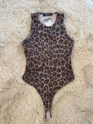 Leopardmönstrad body  - Säljer min leopardmönstrad body från primark! Aldrig använd och lappen sitter kvar. Storlek S men den är stretchig! 🤍😍