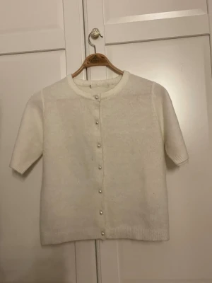 Vit kortärmad kofta från lager 157 - Söt vit kofta med korta ärmar och rund halsringning. Koftan har pärlknappar framtill och är klippt på lager 157 har klippt bort lappen för det sticks men det är xs 