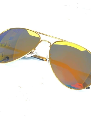 Pilot solglasögon  - Pilot glasögon med metall bågar i Ljusguld och heltäckande glas i metallic färger 