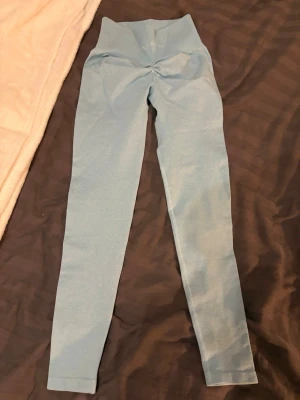 Ljusblå seamless leggings från Nvgtn  - Supersnygga ljusblå seamless leggings med hög midja och scrunch-detalj bak. Stretchigt material som sitter tajt och formar sig efter kroppen. Perfekta för gymmet eller chill hemma. Inga synliga loggor förutom en liten framtill. Storlek XS