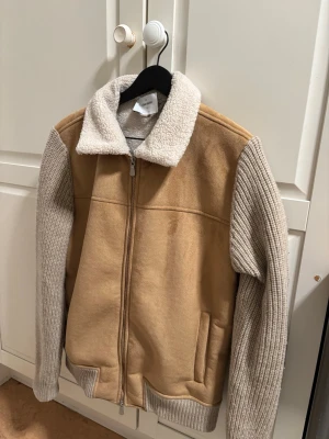 Gran sasso jacka  - Snygg teddyjacka i beige med stickade ljusgrå ärmar och krage i mjuk teddy. Dragkedja framtill och två fickor. Perfekt för dig som vill ha en trendig och mysig jacka med cool kontrast mellan material. Jackan är från märket gran sasso. Jackan är köpt på Ströms i Stockholm för ett nypris på 6000 kr (kvitto finns). Jackan är används endast ett par gånger under en vinter. 