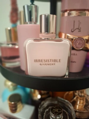 Irresistible Velvet från Givenchy - Lyxig parfym från Givenchy i serien Irresistible. Flaskan är ljusrosa med elegant, fyrkantig form och har en blank, silverfärgad kork. Designen är stilren och modern, perfekt för dig som gillar exklusiva dofter och snygga flaskor i badrumshyllan.